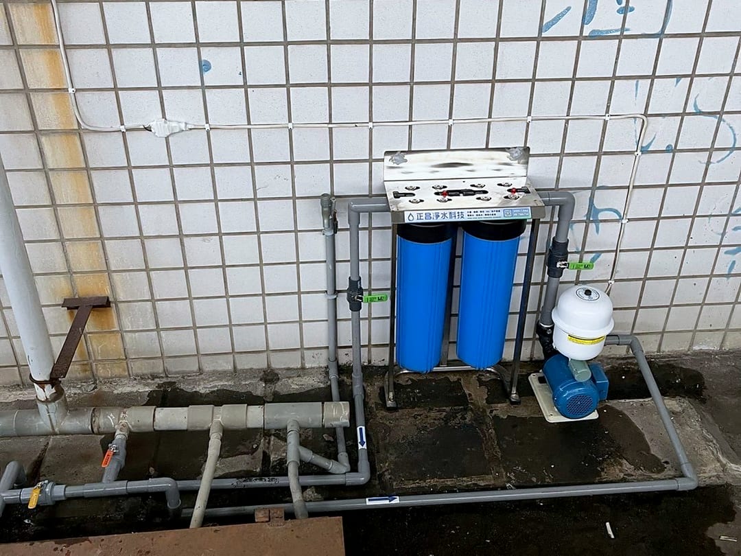 磁磚牆前的雙道全戶式濾水器，旁邊接著加壓馬達