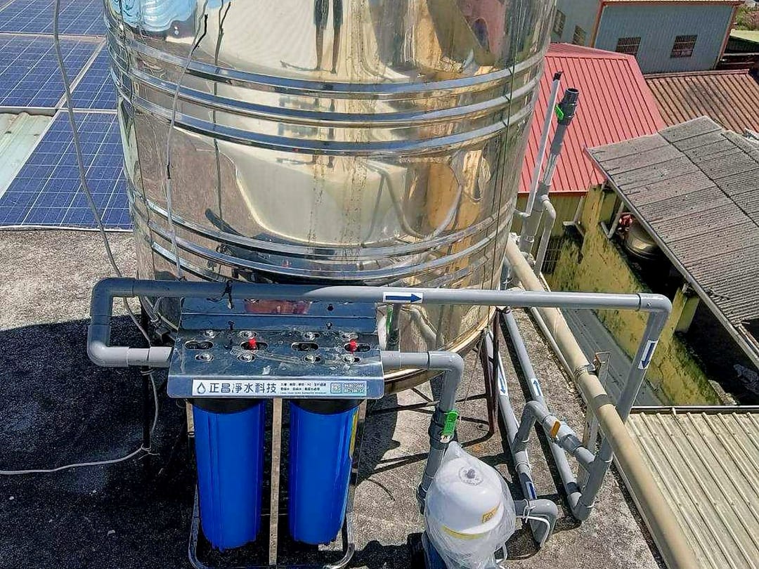 頂樓不鏽鋼水塔下方的雙道全戶式濾水器，旁邊是加壓馬達的壓力桶