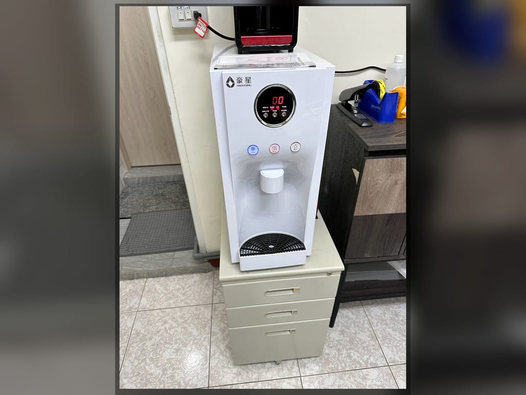 智慧三溫機桌上型放在矮櫃上，靠廚房門邊