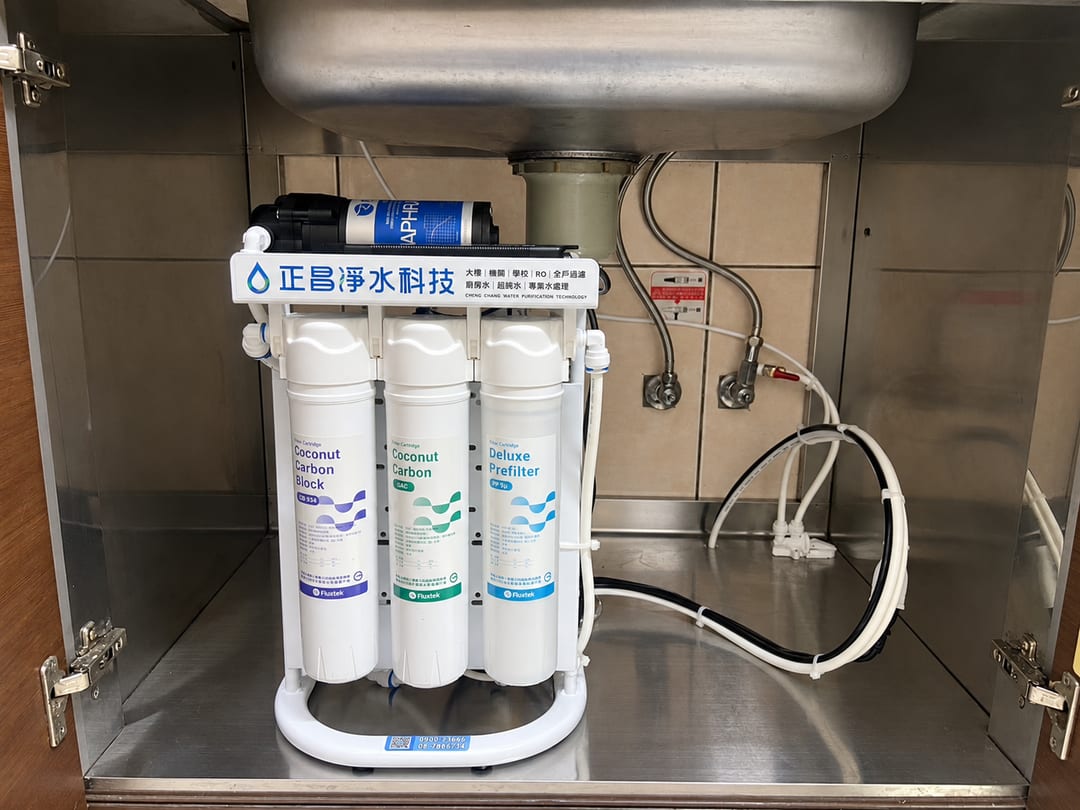 不鏽鋼廚櫃裡的直輸型 RO 主機，配管沿櫃壁走