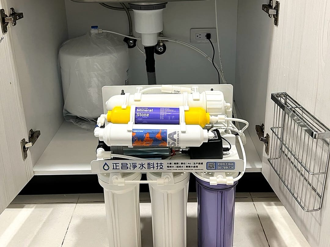 白色廚櫃裡的有壓力桶 RO 機，壓力桶在左、主機在右