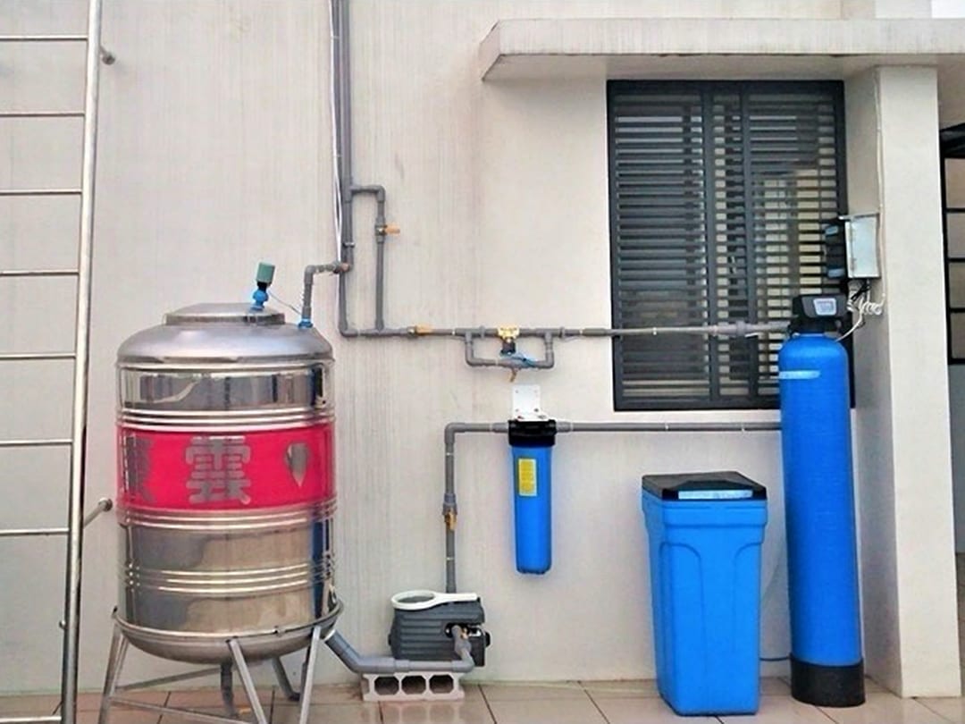 頂樓水塔旁的全戶自動軟化組：藍色樹酯桶、鹽桶與前置濾瓶，旁邊是不鏽鋼水塔
