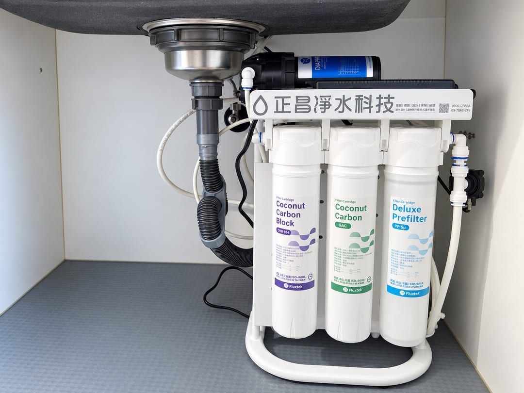 廚下安裝的直輸型 RO 主機，三支濾心並排，上方是加壓馬達